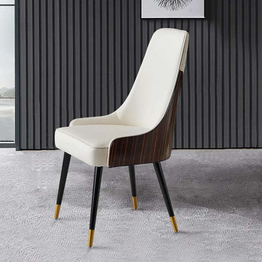 A Walnut Back Faux Leather Dining Chair with a high backrest and white seating surface, set against a backdrop of vertical black and gray paneling and a light-colored carpet.